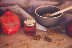 Jewish National Holiday. Rosh Hashana with honey, apple and pomegranate on wooden table.