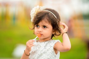 Girl wearing white eating candy