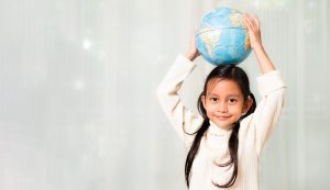 Banner of happy asian little girl is raising bilingual globe model on wihte background. Concept of preserve, save and protect the earth from environment problem, global warming, kid education.
