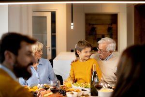 Happy family having a Shabbat dinner with red wine at home